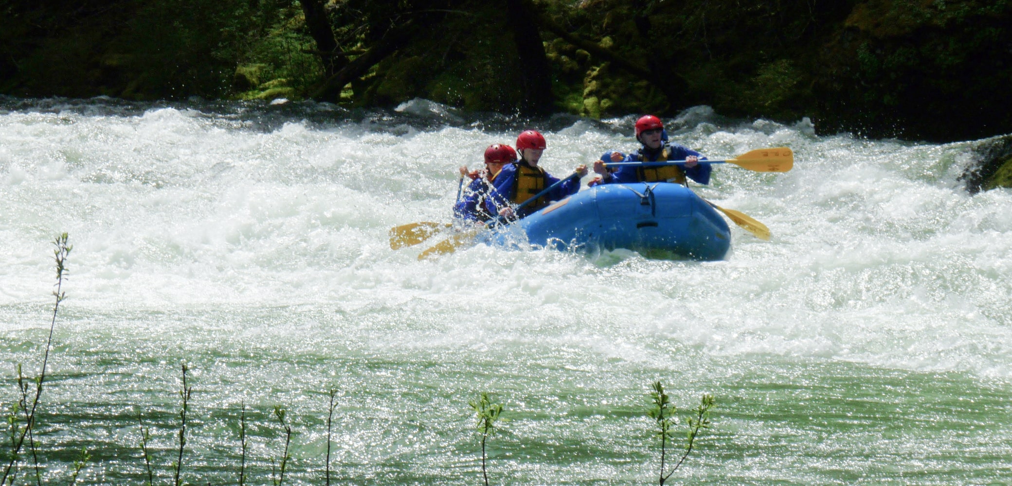 A group of white water rafters exit intense rapids on the Sandy River.