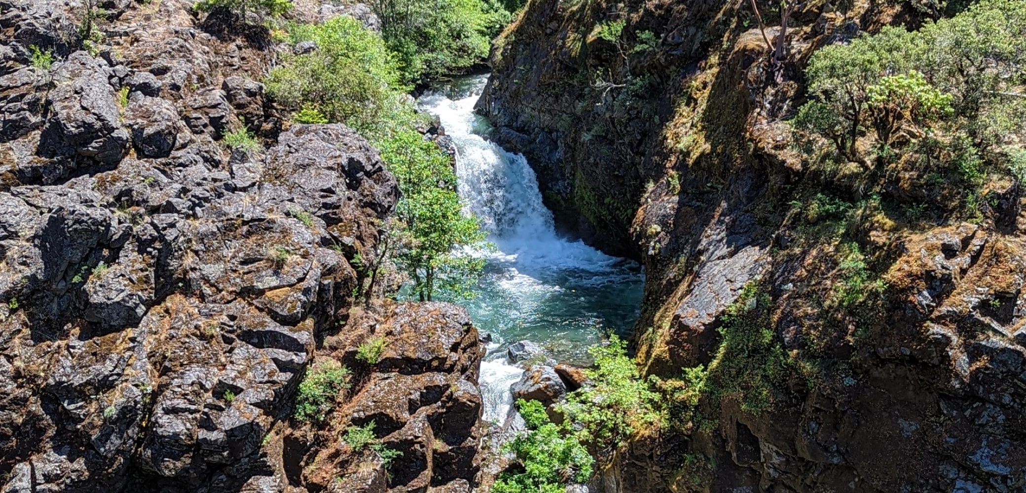 A waterfall on the Rogue River in Oregon between canyon rocks.