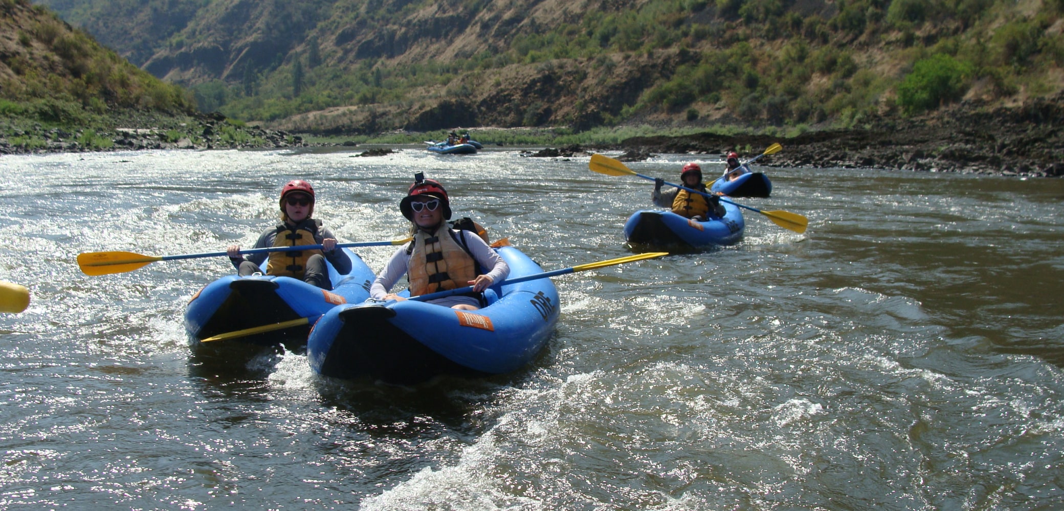 A close up group of happy Kayakers on blue inflatable kayaks on the Salmon River.