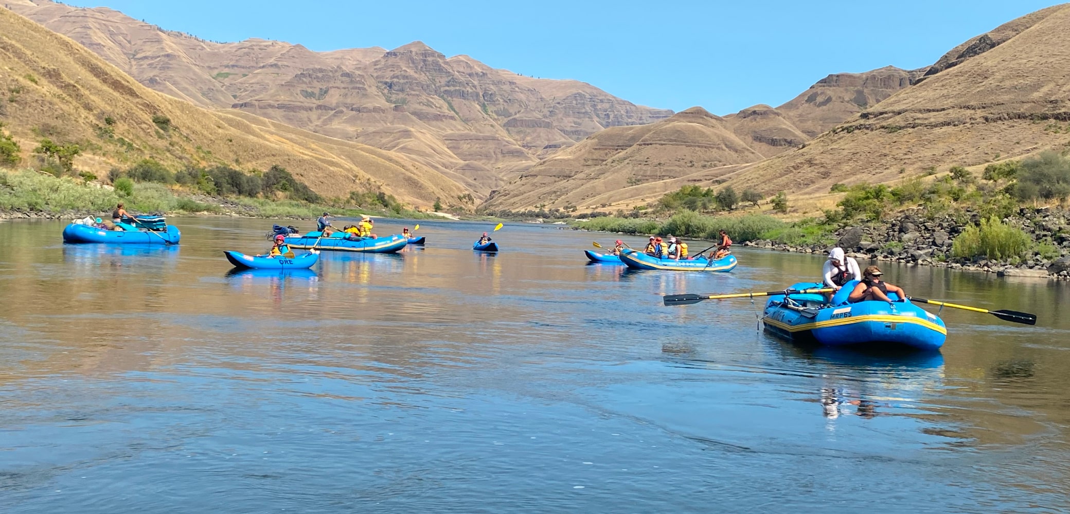 A group of four guided river rafts and four inflatable kayaks paddle down the lower Salmon River.