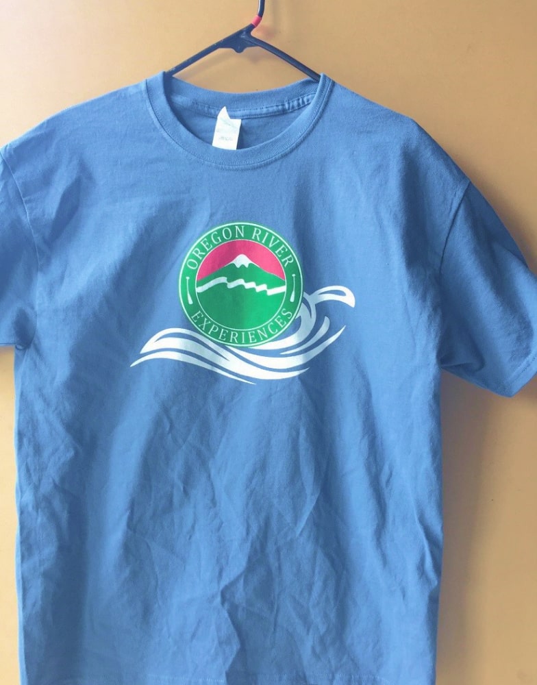 A blue cotton t-shirt with the Oregon River Experiences logo on the front chest.